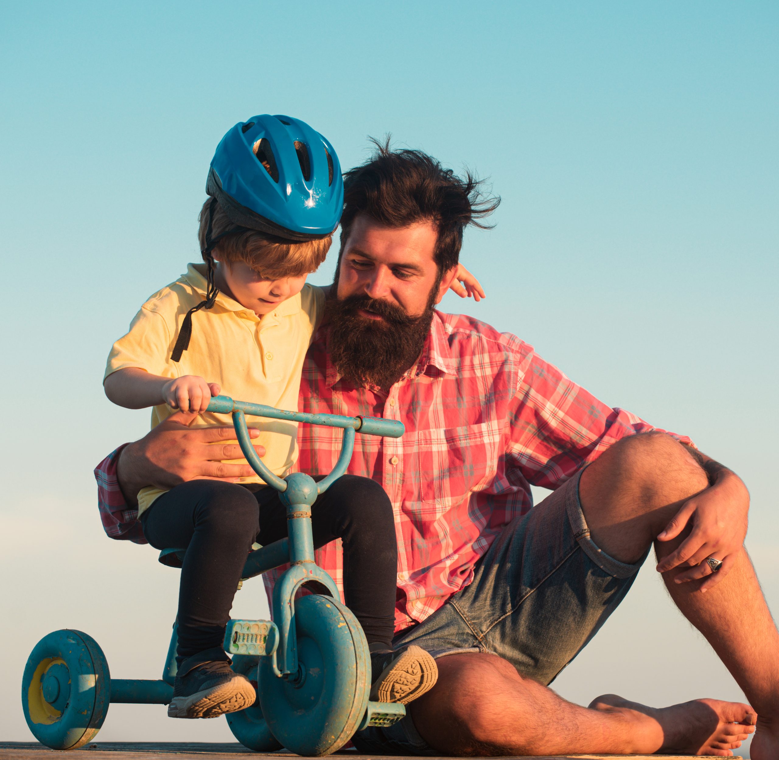 Father teaching son riding bike. Happy dad helping excited son to ride a bicycle. Trust and support. Feeling support from parent, Parental. Fathers day